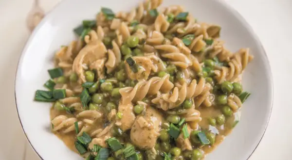 Makaron fusilli z kurczakiem, groszkiem i szczypiorkiem w sosie.