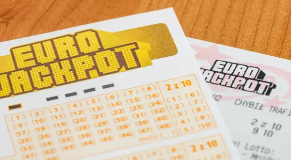 Zbliżenie na kupony Eurojackpot z zaznaczonymi liczbami i tekstem "2 z 10".