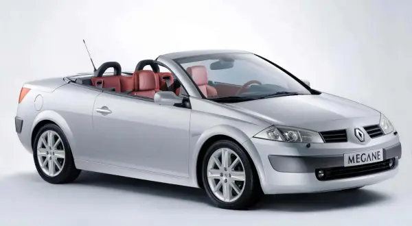 Srebrny Renault Megane cabrio z czerwonymi skórzanymi siedzeniami, gotowy na letnią przejażdżkę.
