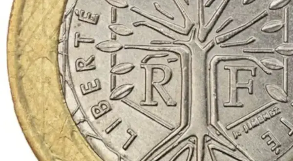 Detalle de una moneda de la República Francesa con un árbol estilizado y las letras "R" y "F".