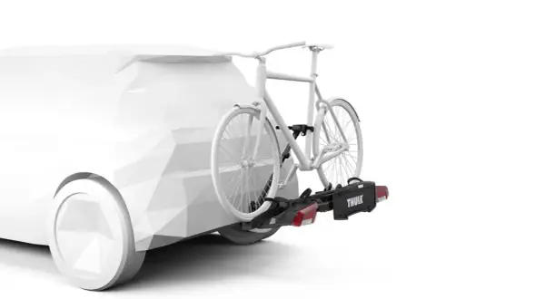 En vit cykel fästs på en dragkrok med en Thule-cykelhållare. Perfekt för att frakta cykeln på semestern.