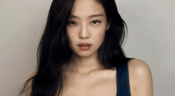 Jennie z BLACKPINK, z długimi czarnymi włosami i delikatnym makijażem, wygląda na zdjęciu jakby zastanawiała się, czy jennie z blackpink ma dzieci.