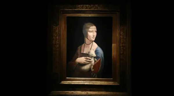 Obraz Dama z łasiczką, Leonarda da Vinci. Młoda kobieta w niebieskiej sukni trzyma w ramionach białego zwierzątko.