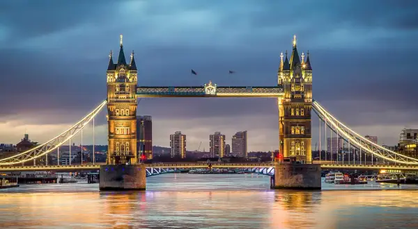 Wieczorna panorama Mostu Tower Bridge w Londynie z oświetlonymi wieżami i rzeką Tamizą.