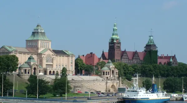 Co warto zobaczyć w Szczecinie? Imponujące budynki Muzeum Narodowego i Zamku Książąt Pomorskich, cumujące statki i zielone wzgórza tworzą malowniczy widok.