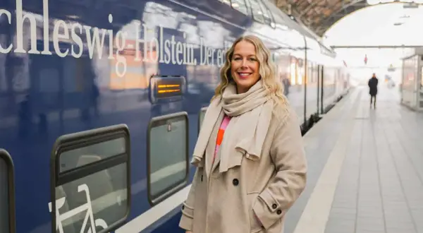 Frau am Bahnsteig in Schleswig-Holstein, bereit für neue Abenteuer. Hier sind einige Flensburg Tipps für deine Reise!