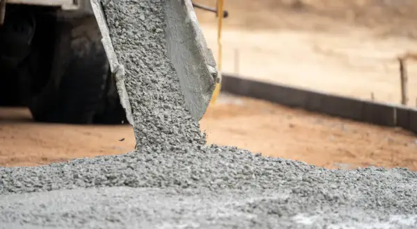 Beton wylewany z gruszki na budowie. Czy droga jest obiektem budowlanym? Powstaje nowa nawierzchnia.
