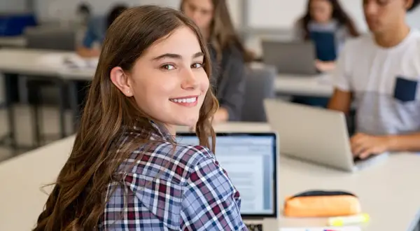 Schülerinnen und Schüler im Deutschunterricht, die an Laptops arbeiten. Ein Beispiel für ein interview schreiben.