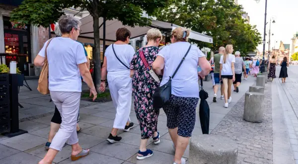 Grupa kobiet po 60-tce spaceruje po mieście. Być może rozmawiają o możliwościach, jakie daje stały zasiłek dla bezrobotnych po 60 roku życia.