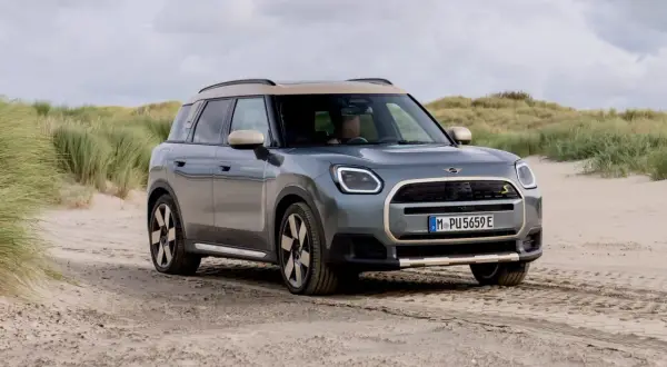 Grå Mini Cooper Countryman på sandig väg vid en strand. En del av en mini cooper countryman test.