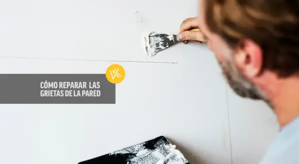 Hombre aplicando masilla para tapar grietas en la pared.