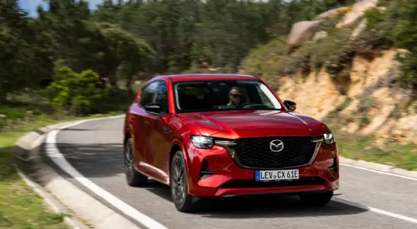 Czerwona Mazda CX-60 na krętej drodze. Poznaj jej imponujące mazda cx 60 wymiary i ciesz się jazdą.