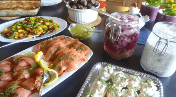 Ett härligt påskbord med mat som gravad lax, köttbullar, sill och ägghalvor.