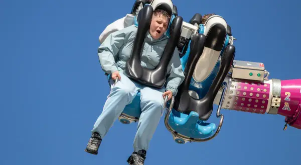 Junge auf einer wilden Fahrt auf der Kirmes Ründeroth, der Wind weht durch sein Haar.