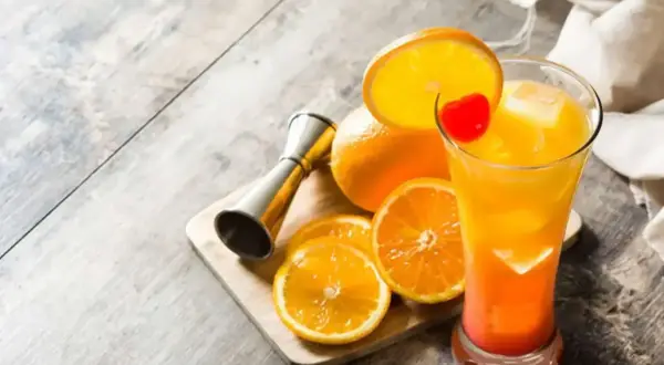 Kolorowy drink Tequila Sunrise, pomarańcze i miarka barmańska. Idealny przepis na lato!