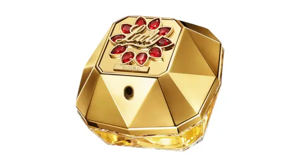 Złoty flakon perfum Paco Rabanne Lady Million Lucky, ozdobiony czerwonymi kamieniami i napisem "ROYAL", emanuje luksusem i szczęściem.
