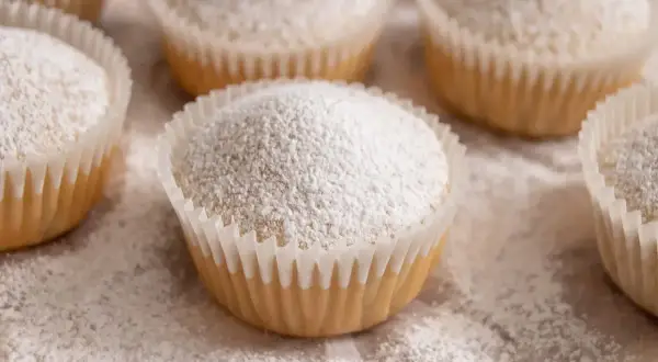 Muffin senza uova, soffici e spolverati di zucchero a velo, pronti per essere gustati.