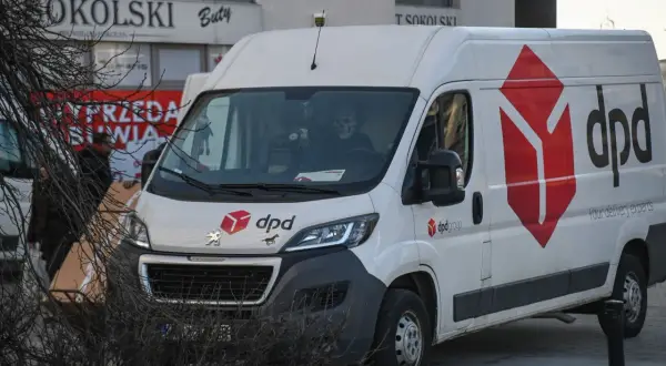 Biały van DPD z logo firmy. W kabinie siedzi kierowca w masce czaszki.