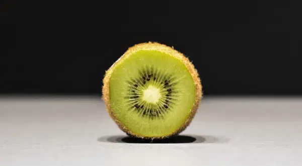 Połówka kiwi, idealna na keto, z widocznymi czarnymi pestkami i zielonym miąższem.