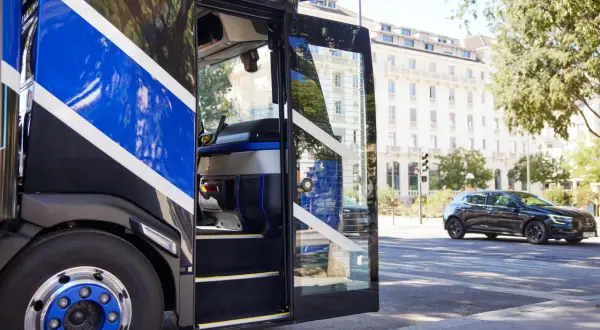 Cabine ouverte d'un camion Renault Trucks, avec des bandes bleues vives. L'air frais de la ville, comme de l'oxygène, circule.