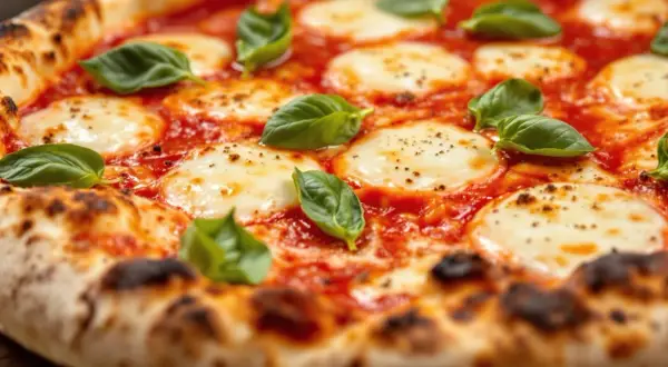 En närbild av en napolitansk pizza med smält mozzarella, tomatsås och färsk basilika. Ost till napolitansk pizza är perfekt!