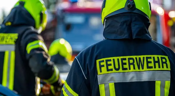 Feuerwehrleute in voller Montur, bereit für den Einsatz. Interessiert, wie viel verdient man als Feuerwehrmann netto?