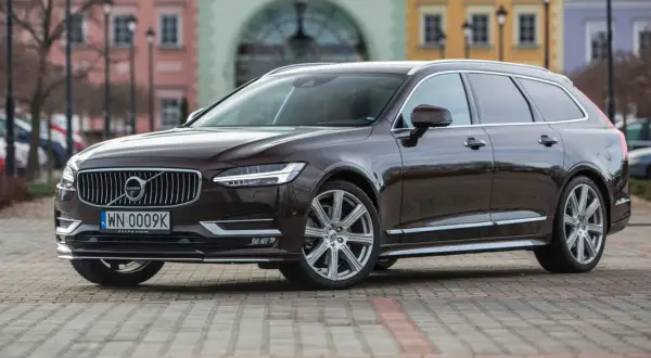Brązowe Volvo V90 na tle kamienic. Sprawdź akcje serwisowe Volvo po VIN, aby upewnić się, że Twój samochód jest bezpieczny.