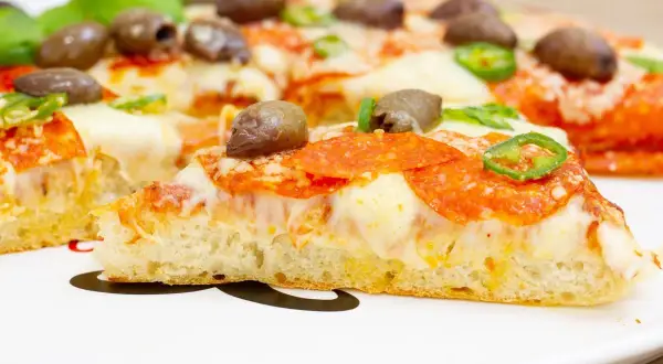 Pyszna pizza z patelni z pikantnym salami, oliwkami i papryczką jalapeno. Idealna na szybki obiad.