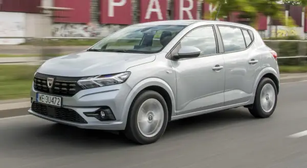 Srebrny Dacia Sandero w ruchu miejskim. Wiele osób chwali ten model za stosunek ceny do jakości, co potwierdzają liczne dacia sandero opinie.