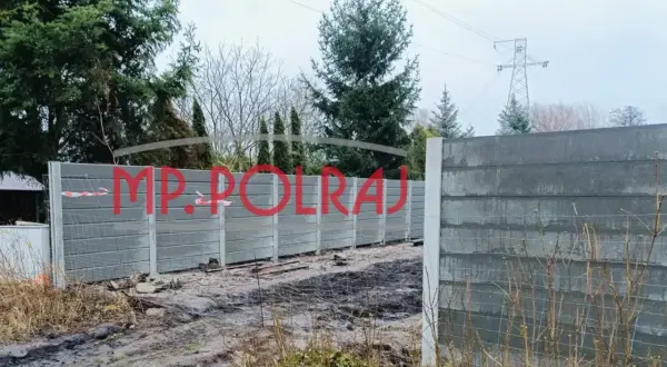 Gotowy fundament pod ogrodzenie, czekający na pozwolenie. W tle drzewa i linia energetyczna.