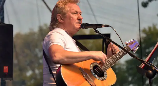 Janusz Laskowski śpiewa i gra na gitarze podczas kolorowych jarmarków.