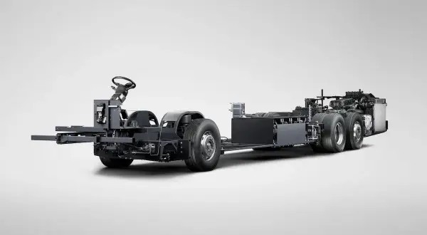Châssis d'un bus Scania hybride, prêt à être assemblé, avec son volant et ses roues visibles.