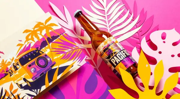 Butelka piwa Pacific z etykietą w stylu retro, obok grafiki z kamperem i palmami. To idealny towarzysz podróży od browaru artezan.