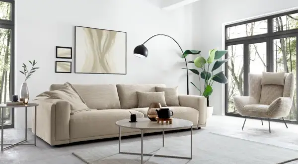 Gemütliches Wohnzimmer mit beigem Sofa, Sessel und Couchtisch. Tolle wohnideen modern für ein stilvolles Zuhause.