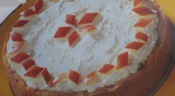 Eine köstliche Apfel Sekt Torte mit Sahnehaube und roten Apfelstücken verziert.