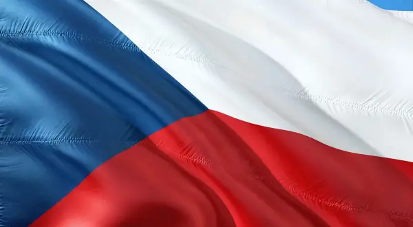 Flaga Czech falująca na wietrze. Kraj ten słynie z piwa, ale warto pamiętać o **Czechy limit alkoholu**, by cieszyć się podróżą.