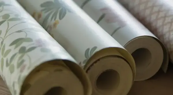 Rullar med tapet i olika mönster. Frågan om hur många våder på en tapetrulle är relevant för att beräkna materialåtgången.