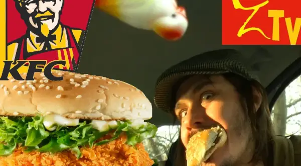 Mężczyzna w czapce z beretem je Zinger KFC. Obok logo KFC i zabawna rybka.