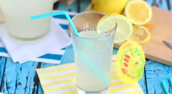 Ett glas hemgjord lemonad med citronskiva och sugrör. Perfekt för ett enkelt lemonad recept en varm sommardag.