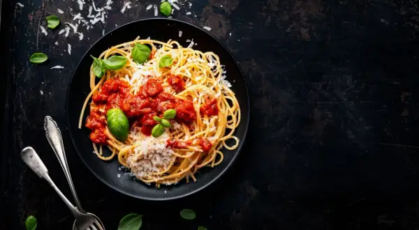 Ein Teller Spaghetti mit Tomatensauce, Parmesan und Basilikum. Perfekt für vegetarische italienische Pasta Rezepte.