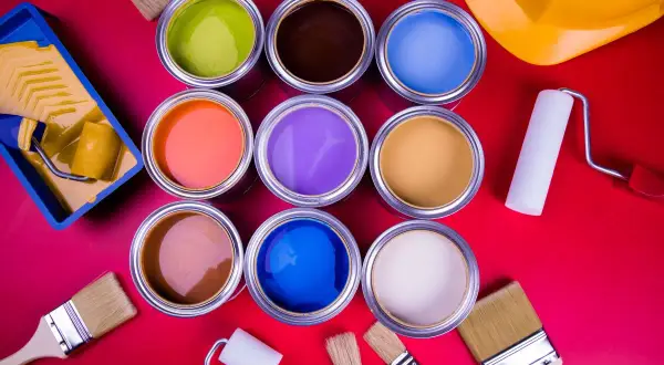 Una tavolozza di colori vivaci: barattoli di vernice aperti, pennelli e rulli pronti per trasformare ogni spazio.