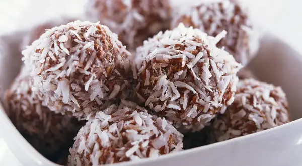 En skål med nyttiga chokladbollar, rullade i kokosflingor. Perfekta för fikat!