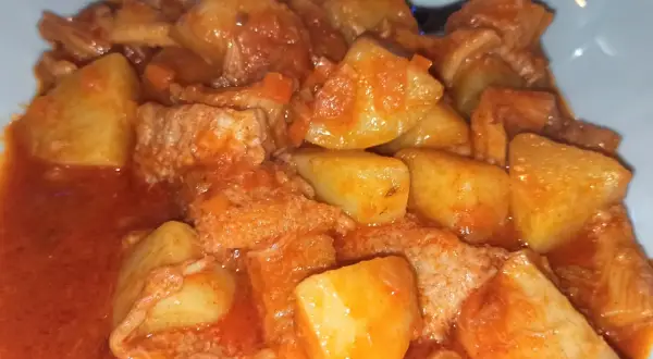 Un saporito piatto di trippa con patate, cotto in un ricco sugo di pomodoro.