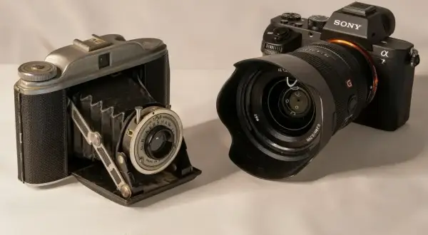 Stary aparat mieszkowy i nowoczesny aparat Sony obok siebie pokazują, jak działa aparat fotograficzny, od prostych mechanizmów po zaawansowaną elektronikę.