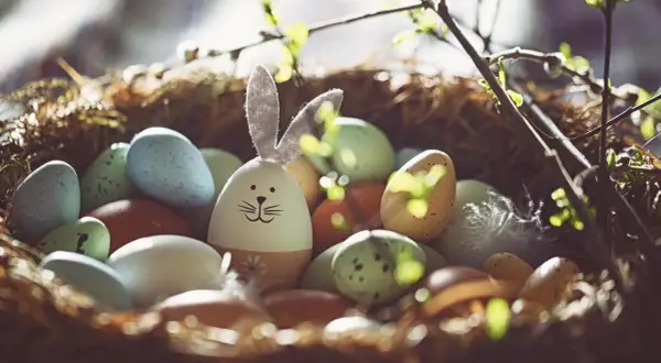 Ein Osternest mit bunten Eiern und einem Hasen-Ei. Ein Symbol für das Christentum und den Neuanfang.