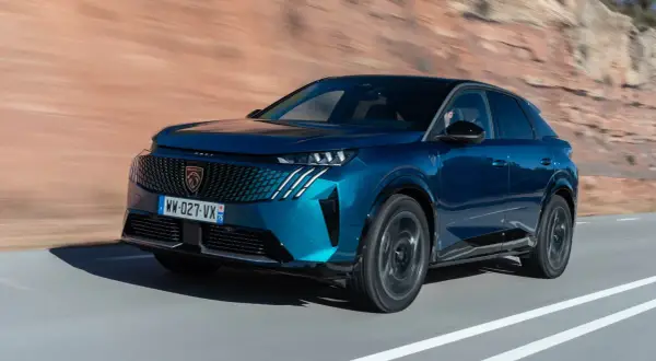 Blå Peugeot 3008 kör på en väg, redo för ett test.