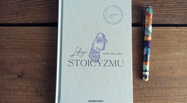 Książka "Lekcje stoicyzmu" Johna Sellarsa obok ozdobnego pióra. Inspiracja dla tych, którzy szukają mądrości w literaturze.