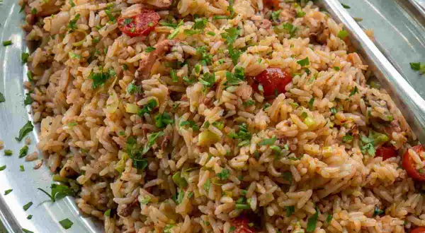 Un invitante insalata di riso di mare, ricca di pomodorini, erbe aromatiche e pezzi di pesce, pronta per essere gustata.