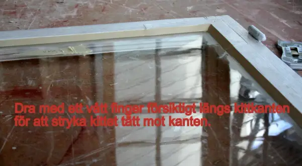 Fönsterkarm med nyligen applicerat kitt. Dra med ett vått finger längs kittkanten för att jämna till.