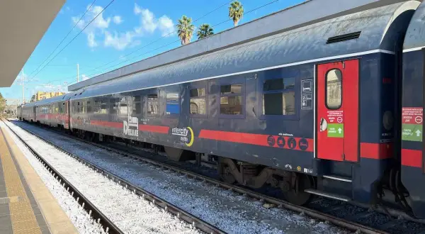 Ein langer Zug mit der Aufschrift "Intercity notte" und "DELUXE" steht am Bahnsteig. Vielleicht geht es **mit dem Zug nach Griechenland**?